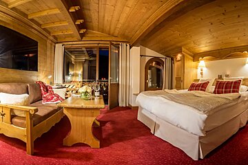 A hotel room with a large bed and a couch