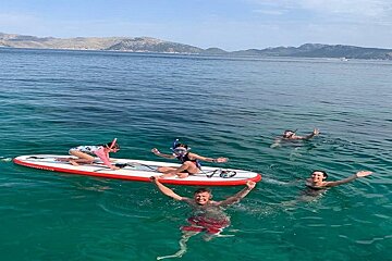 A group of people are floating on paddle boards in the ocean