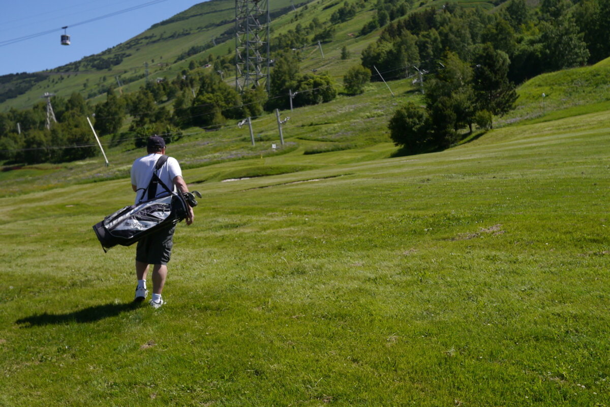 a man carrying a golf bag