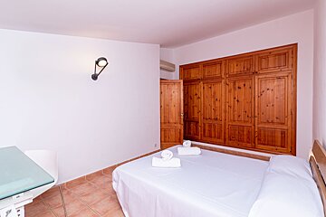 A bedroom with a large closet and a bed