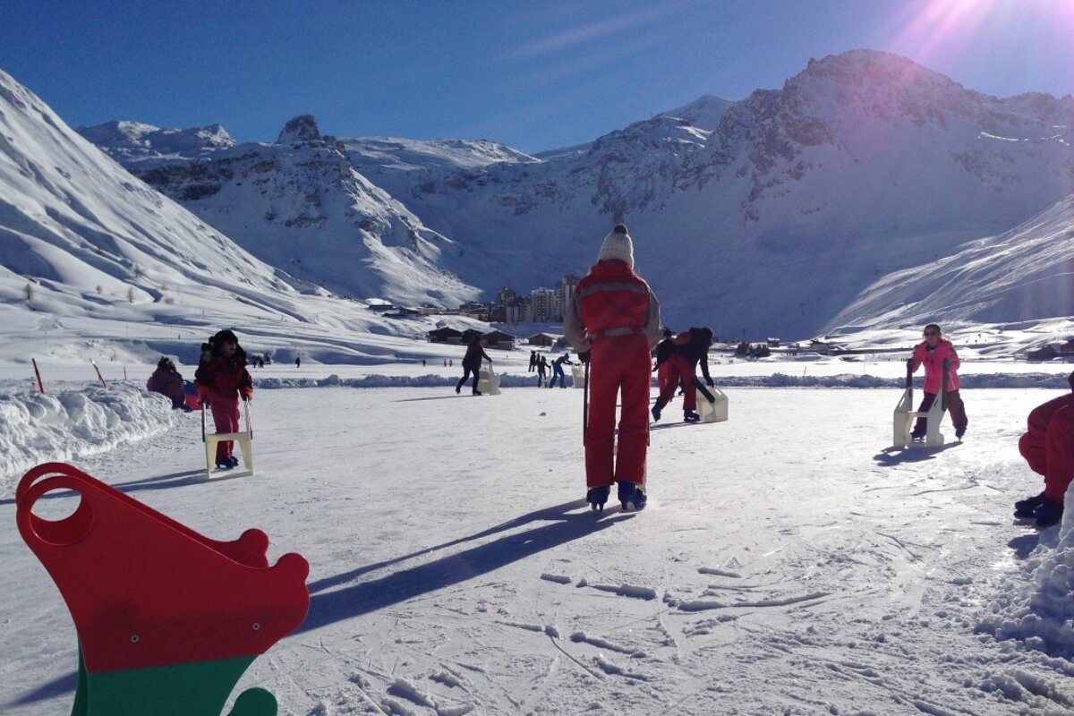 A group of people are ice skating in the snow