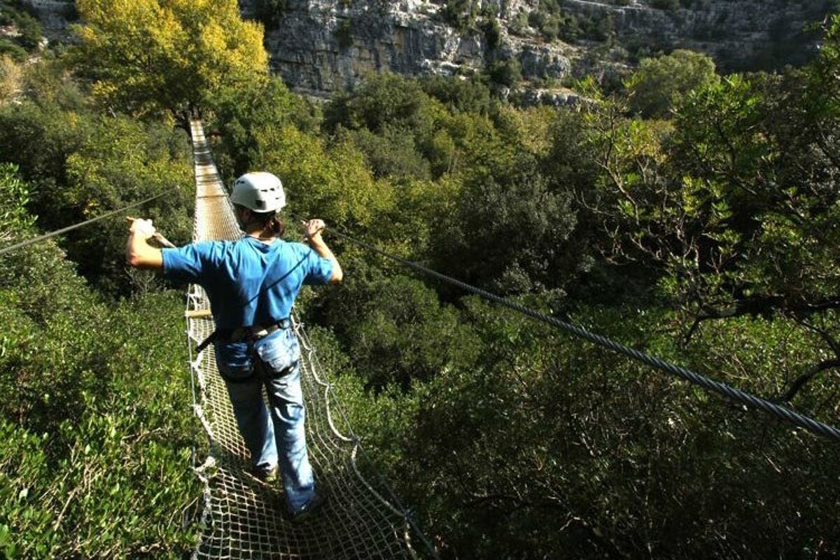 woman walking over a rope bridge