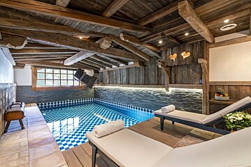A large indoor swimming pool with a wooden ceiling