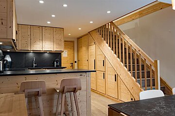 A kitchen with wooden cabinets and a black counter top