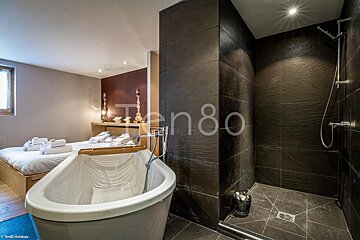 A bathroom with a bathtub and a shower that says ten80