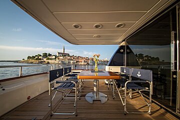 A table and chairs on the deck of a boat