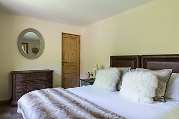 A bedroom with a bed dresser and mirror