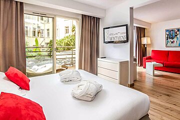A hotel room with a large bed and a flat screen tv