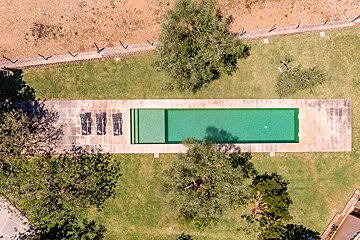 An aerial view of a large swimming pool surrounded by trees