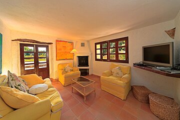 A living room with yellow furniture and a flat screen tv