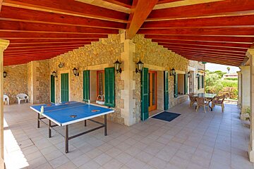 A ping pong table sits under a wooden roof
