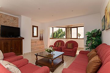 A living room with red furniture and a flat screen tv