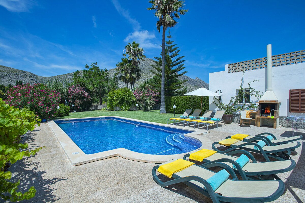 A large swimming pool surrounded by chairs and umbrellas