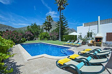 A large swimming pool surrounded by chairs and umbrellas
