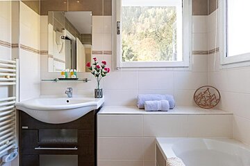 A bathroom with a sink and a bathtub and a window