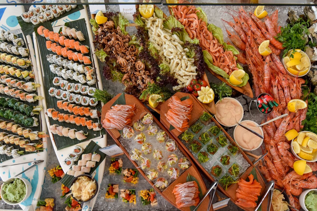 A buffet table with a sign that says ' sushi ' on it