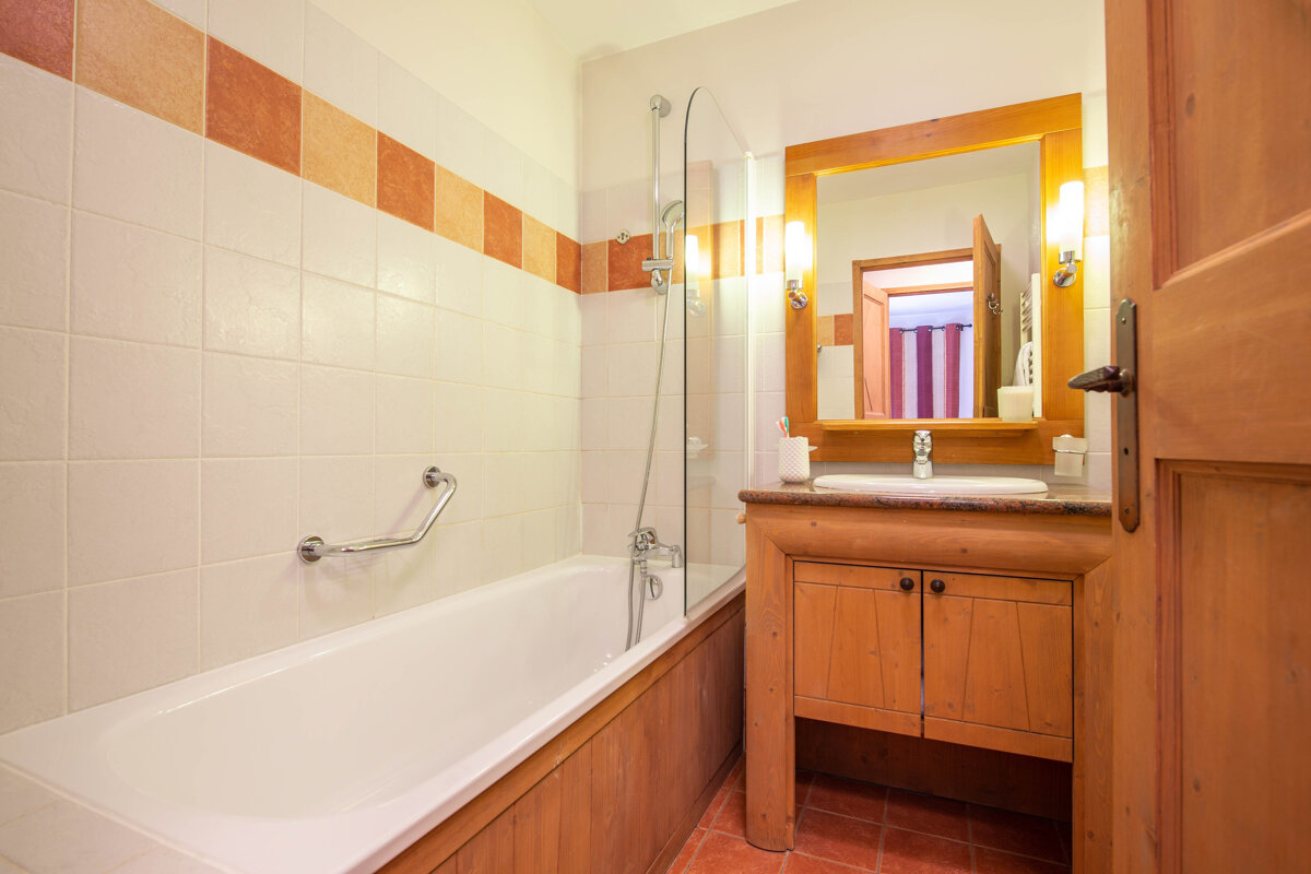 A bathroom with a bathtub sink and mirror