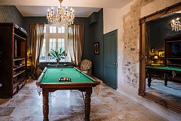 A pool table in a room with a large mirror