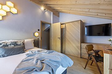 A bedroom with a bed and a flat screen tv