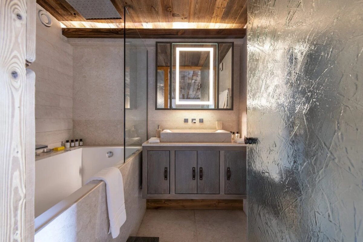 A bathroom with a bathtub sink and mirror