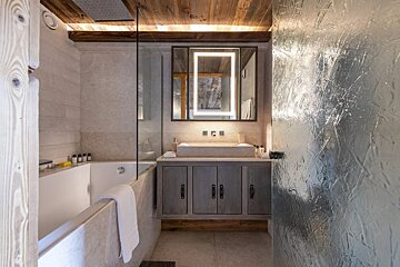 A bathroom with a bathtub sink and mirror