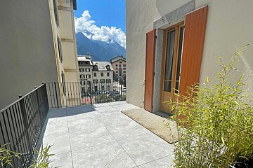 A balcony with a view of mountains and buildings