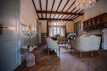 A living room with furniture and a chandelier hanging from the ceiling