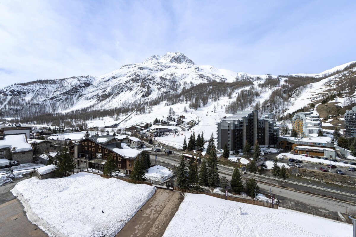 A snowy landscape with a mountain in the background
