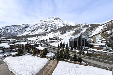 A snowy landscape with a mountain in the background