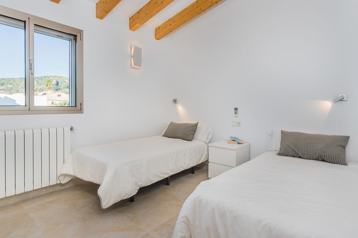 A bedroom with two twin beds and a window