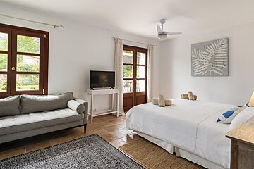 A bedroom with a bed a couch and a television