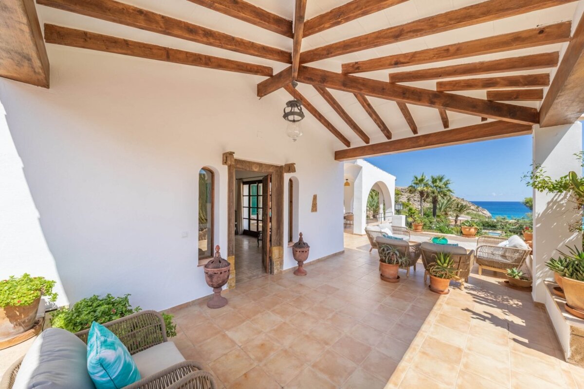 A white house with wooden beams and a view of the ocean