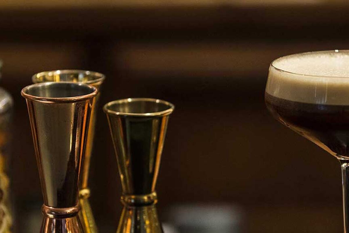 Three measuring cups are next to a martini glass