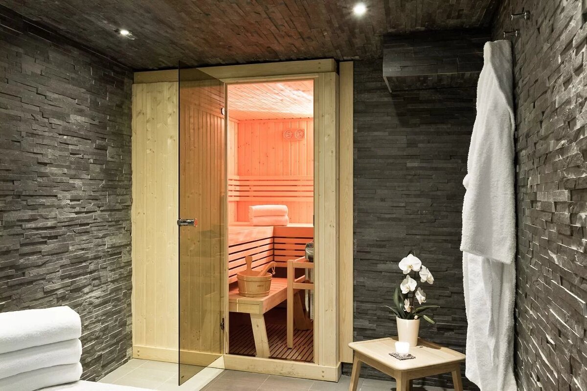A sauna with a glass door and a white robe