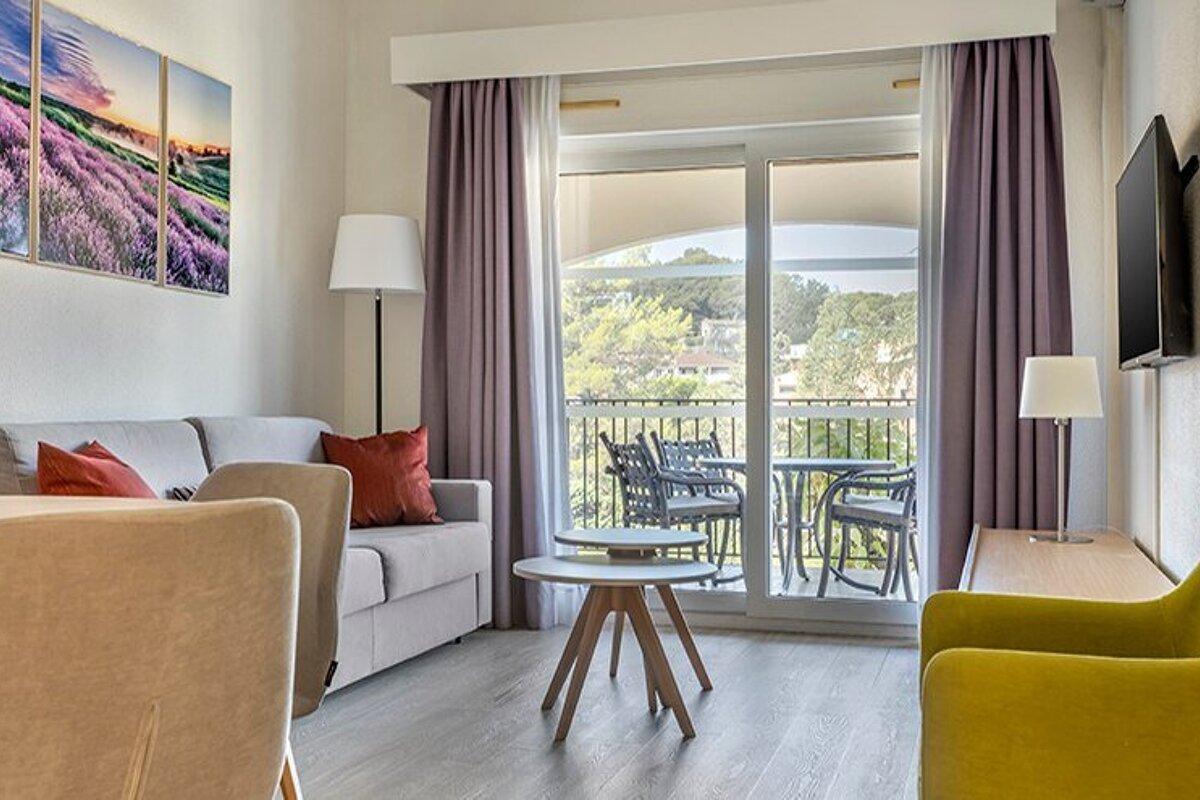 A living room with a couch and chairs and a balcony