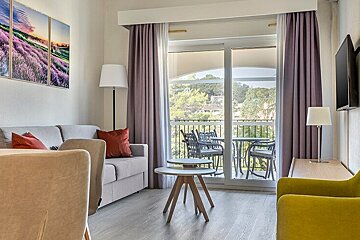 A living room with a couch and chairs and a balcony