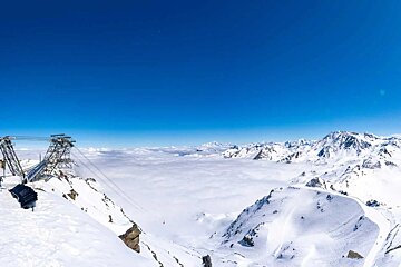 A sea of cloud below the blue sky and sunshine at Cime Caron in Val Thorens