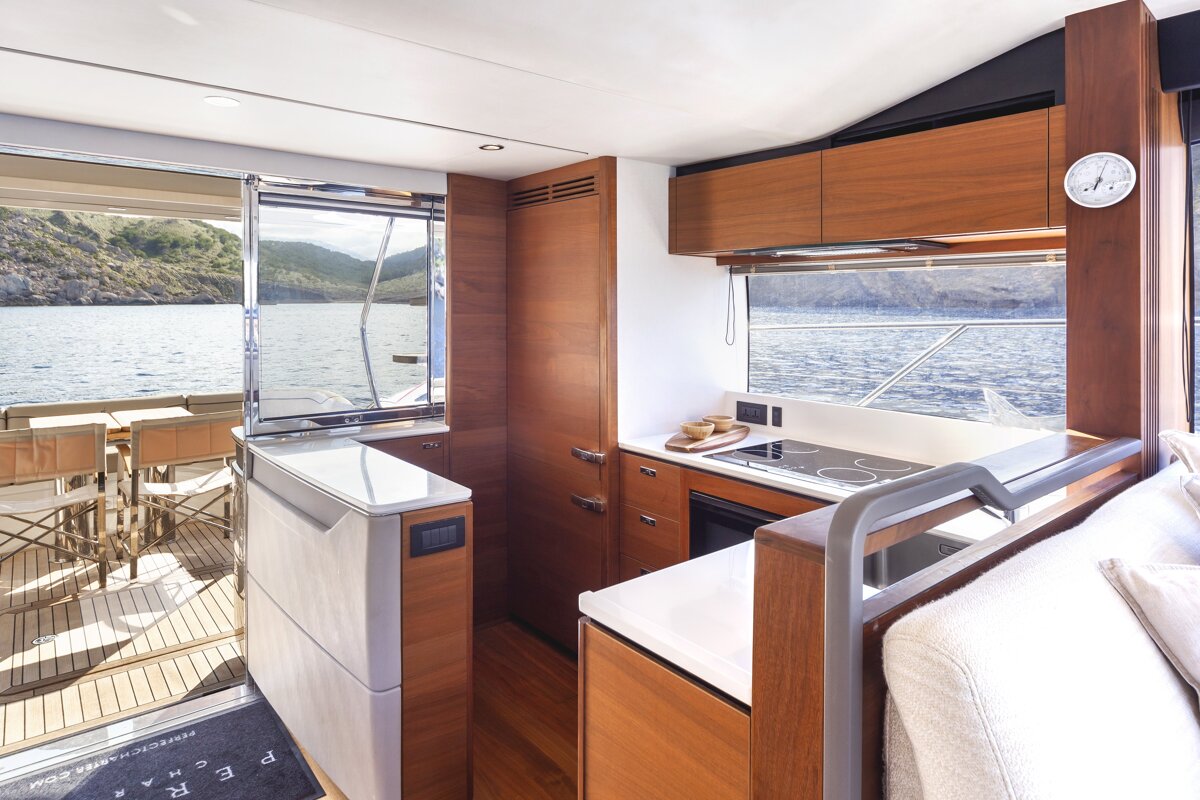 A kitchen on a boat with a clock on the wall