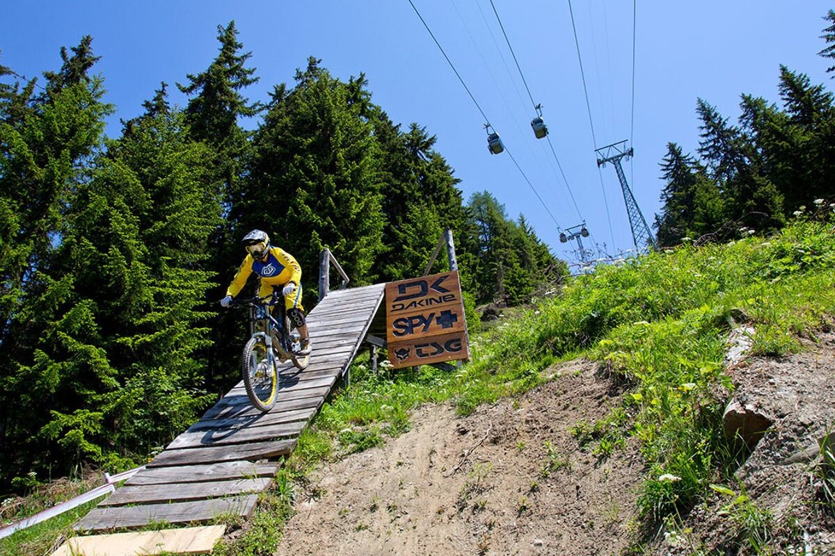 a mountain biker riding down a steep ramp