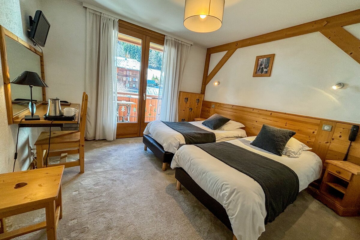 A hotel room with two beds and a desk