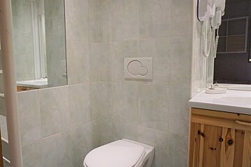 A bathroom with a toilet a sink and a mirror