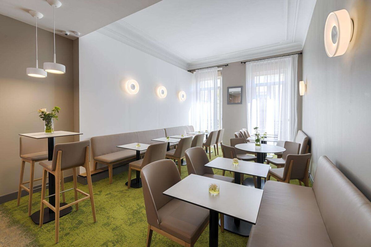Tables and chairs in a room with a green carpet