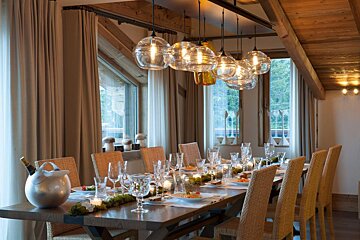 A dining room with a long table and chairs