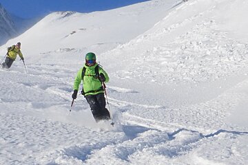 two skiers in knee deep snow