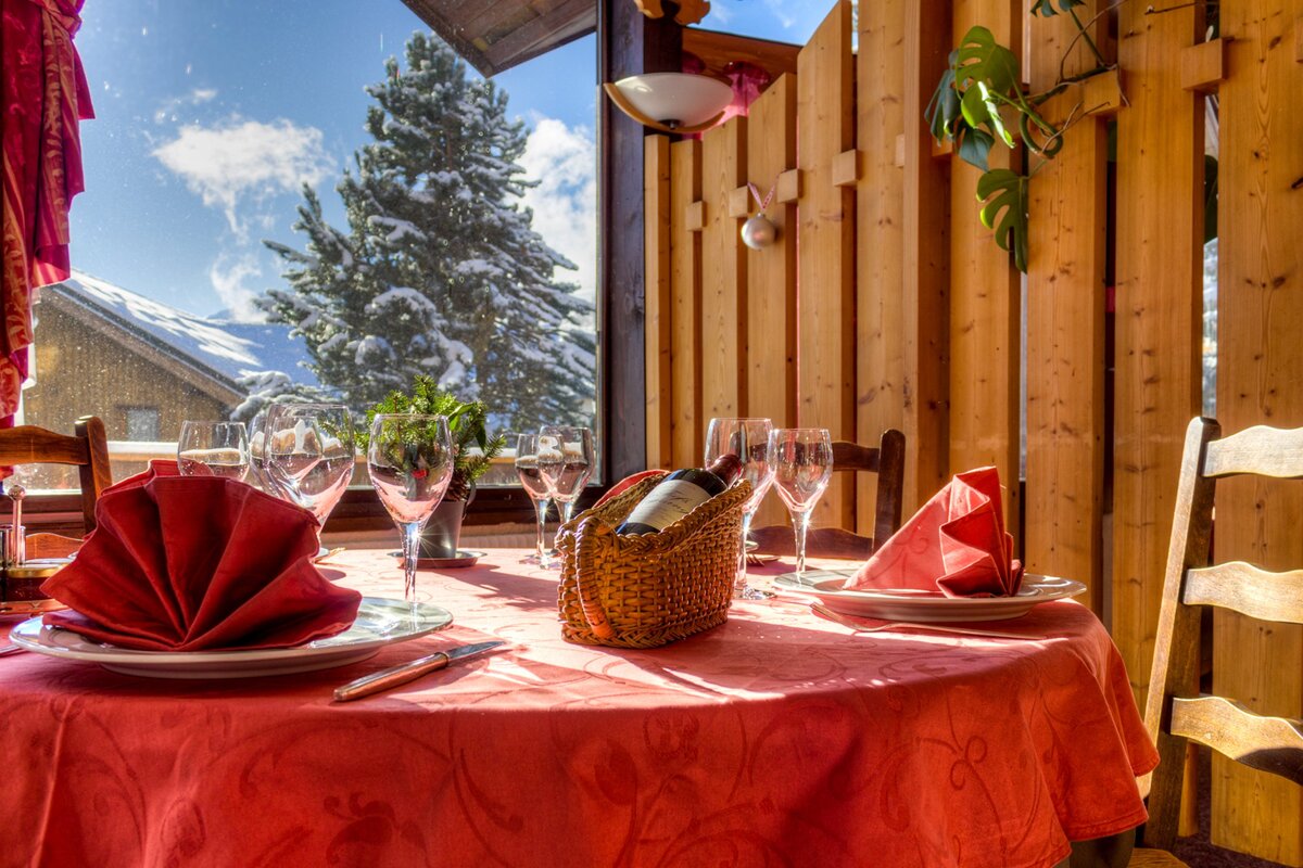 A bottle of wine sits on a table in front of a window