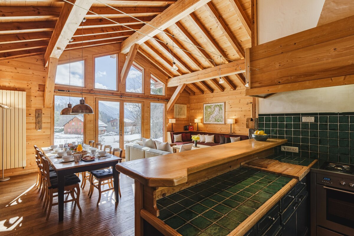 A kitchen with green tiles and a wooden counter top
