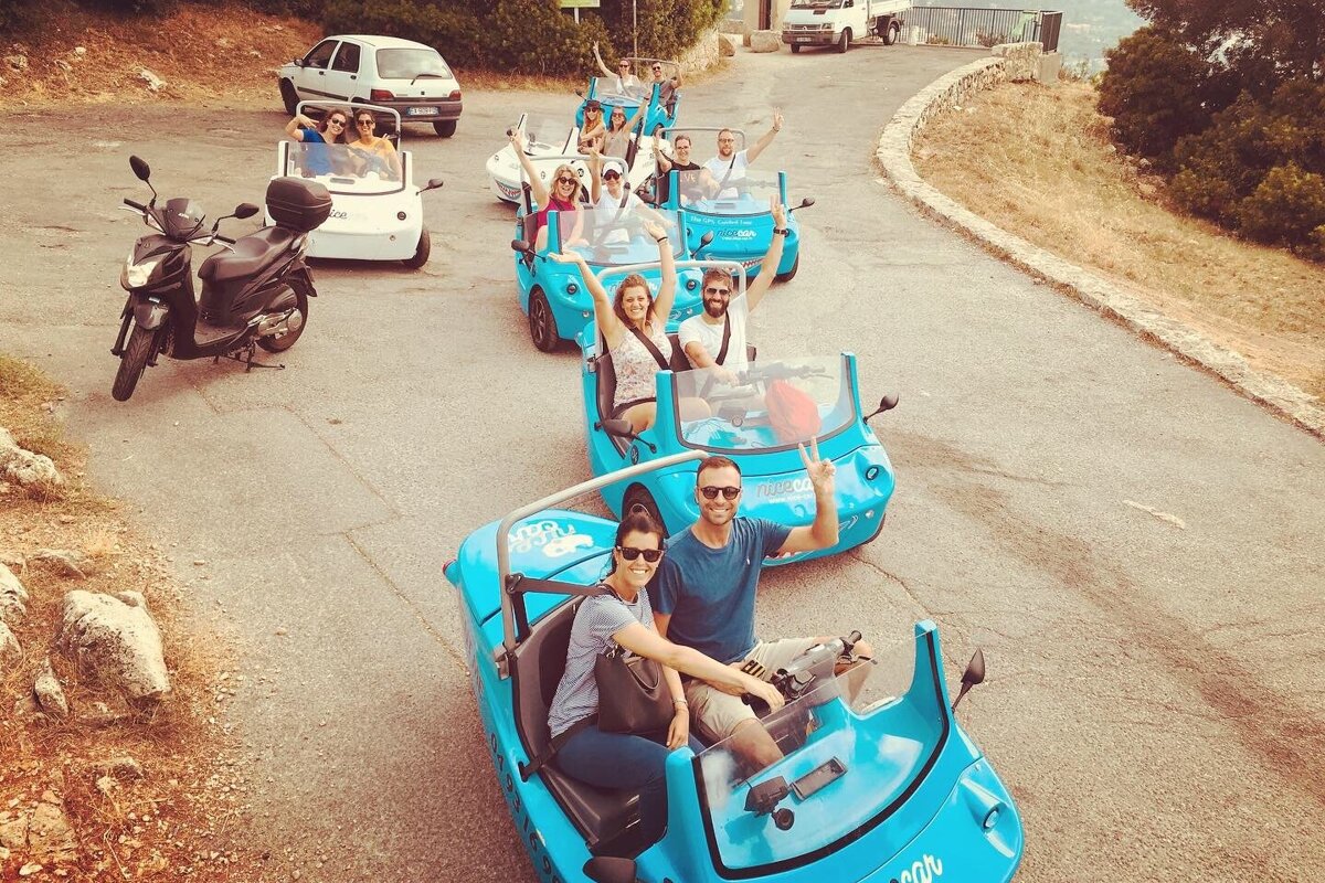 A group of people are riding in a row of blue vehicles that say ' scooter ' on the side