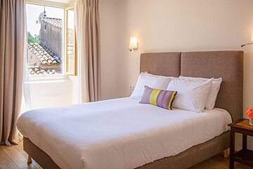 A hotel room with a bed and a window