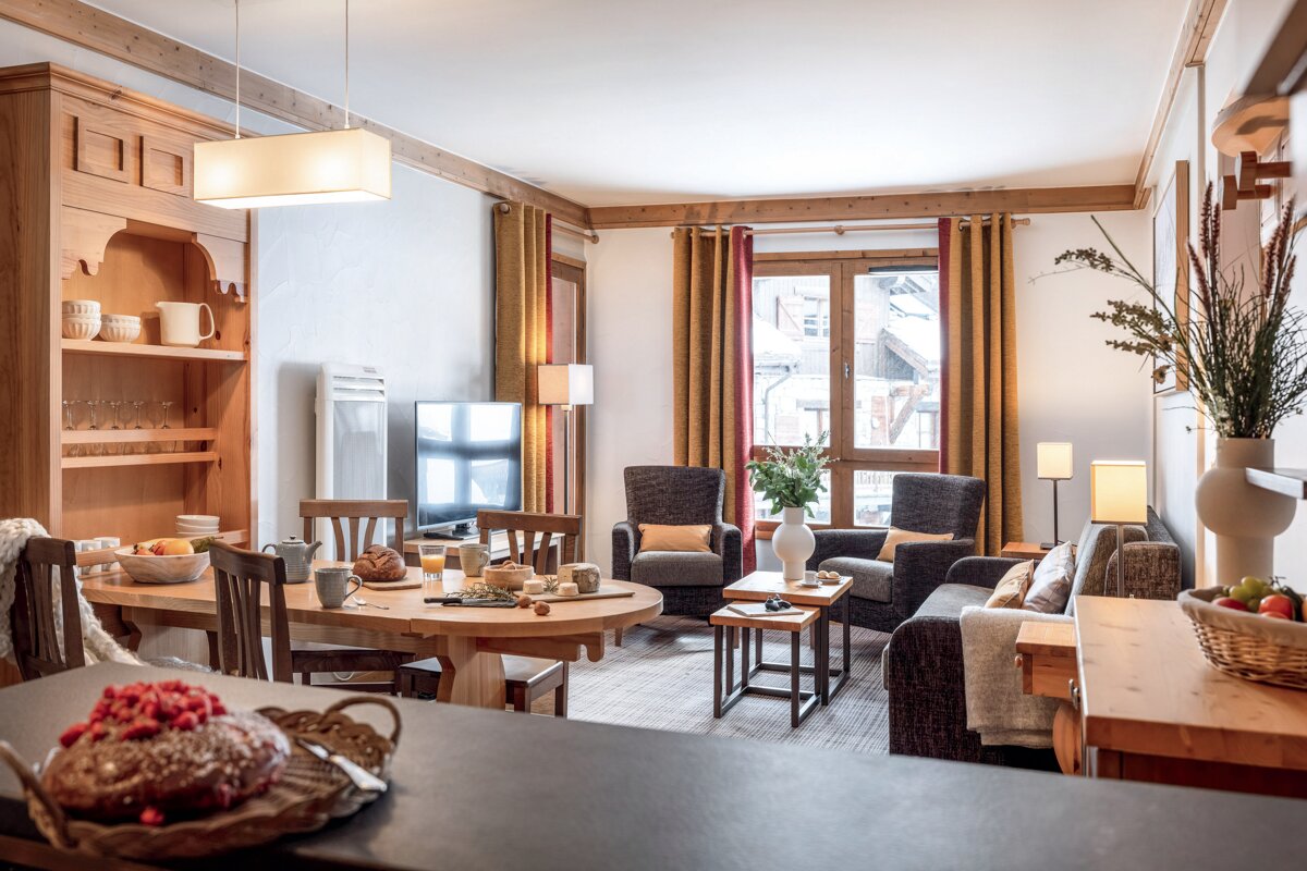 A living room with a couch a table and chairs