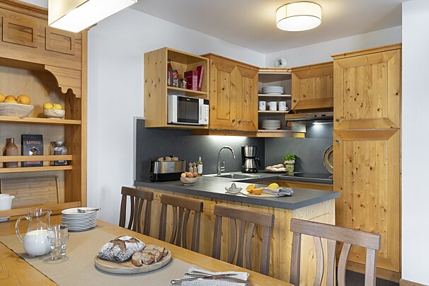 A kitchen with wooden cabinets and a microwave